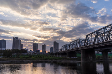 the sun sets in the buildings across the Tama River Kawasaki Kanagawa Japan