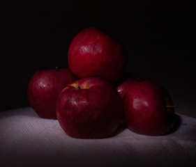 Fototapeta na wymiar fresh red apples on a white tablecloth against black background