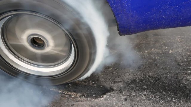 Drag car make tires warm up with smoke, Car racing burnout rubber off its tires in preparation for the race.