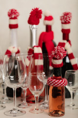 Merry Christmas and Happy New Year! Holiday knitted decor - Santa Claus knitted hats on the bottle with wine.