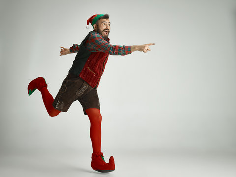 friendly man dressed like a funny gnome posing on an isolated gray background