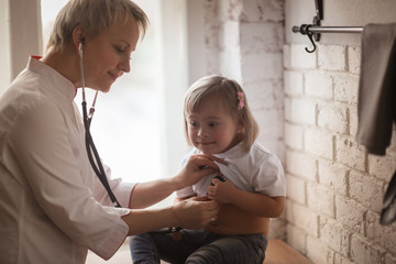 doctor with stethoscope and kid Down syndrome