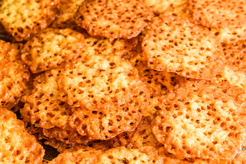 Freshly baked oatmeal lace cookies resting on oven rack.