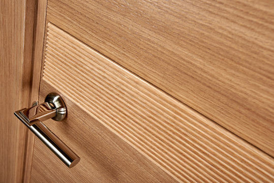 Closeup photo of brown wooden door with metal handle