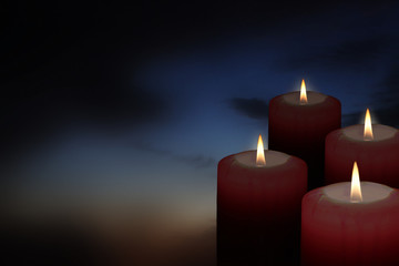 four christmas candles in the dark sky