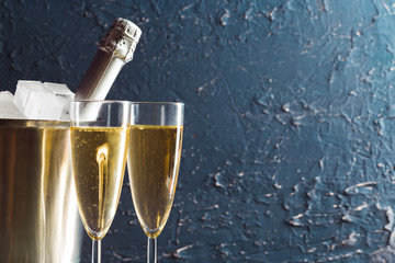 Champagne bottle in bucket with ice and glasses of champagne