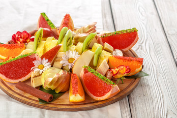 Fresh fruits in plate on wooden table