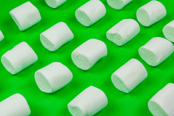 sweet marshmallow, candy on green background, top view