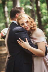 bride and groom on the background of trees and forest sun