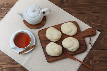 木のまな板にのせた 白パン 紅茶 テーブル