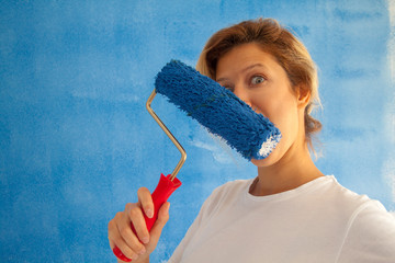 woman painting a wall with paint roller