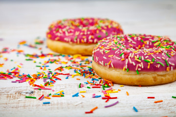 Pink donuts on a wooden background.