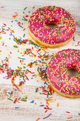 Pink donuts on a wooden background.