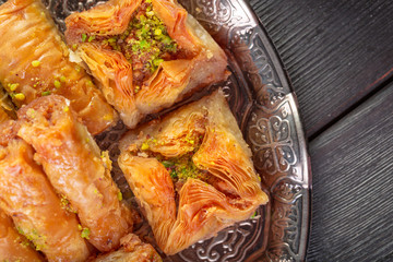 Turkish arabic dessert baklava with honey and nuts on a silver plate