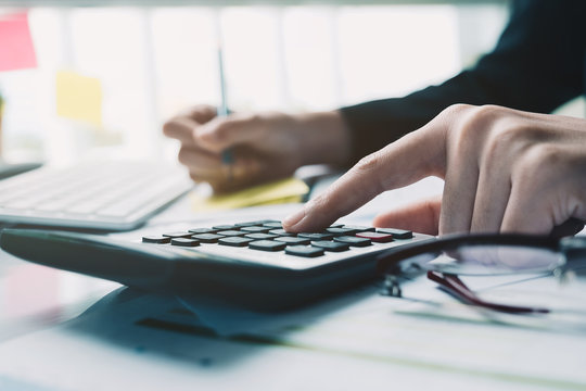 Close up Business woman using calculator for do math finance on desk in office and business working background, tax, accounting, statistics and analytic research concept