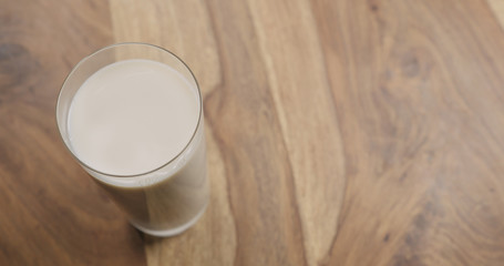 oat milk in glass on wood background with copy space