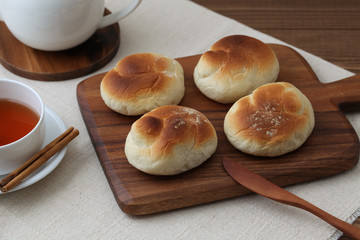 木のまな板にのせた 焼きたて パン 紅茶 ポット テーブル