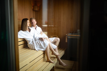 People in bathrobes using sauna at spa resort