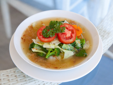 vegetable soup in a plate on a glass table
