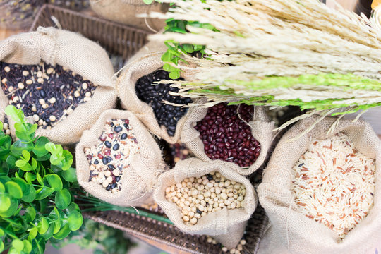 Grains, Beans, Grains And Rice In A Calico Bag On A Wooden Table.