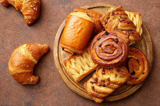 pasticceria dolci cornetti ciambelle e strudel su tavolo marrone