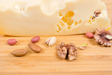 Texture of cut of maasdam cheese among of various nuts