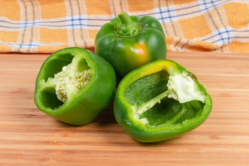 One whole and two different halves of green bell peppers