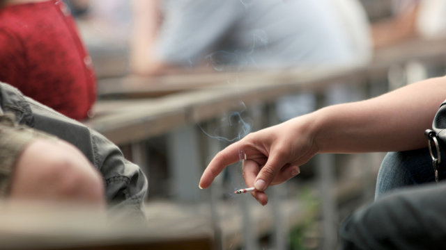 Hand of young person holding cigarette. Unhealthy lifestyle concept. Smoking abuse is harmful to health.