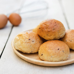 freshly baked bread and egg on white wooden background.