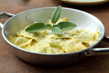 Pasta Italiana ravioli burro  salvia e parmigiano su tavolo di cucina, - obrazy, fototapety, plakaty