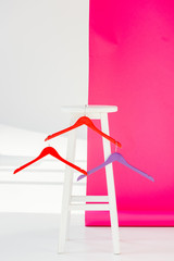 multicolored painted hangers with white wooden chair