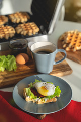 Eggs Benedict with bread and tomato on a plate with becon morning sandwich