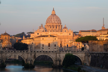 Fototapeta na wymiar St. Peter's Cathedral in Rome, Italy, and the Tiber River against blue sky at sunrise