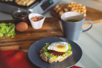 Eggs Benedict with bread and tomato on a plate with becon morning sandwich