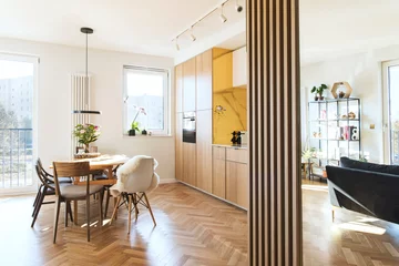 Foto op Plexiglas Stylish scandinavian open space with dining and living room with design sofa and family table. Bright and sunny room with big windows and brown wooden parquet.  © FollowTheFlow