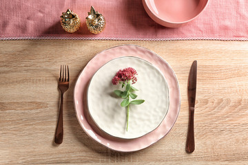 Table setting with flower on wooden background
