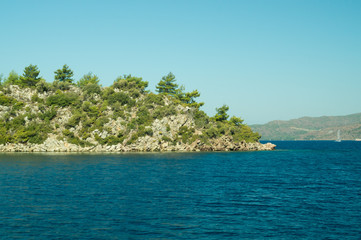 Overgrown mountain on the island. seascape background. water surface