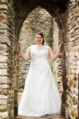 Alone Bride posing in castle ruins after wedding