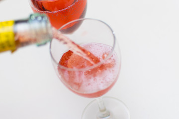 Pouring a glass of pink champagne.