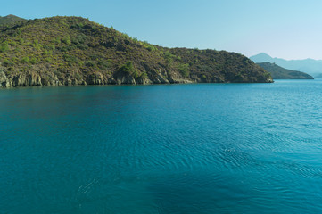 Overgrown mountains on the island. seascape background. water surface in a bay