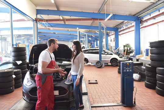 Car mechanic and customer in the workshop // Automechaniker und Kundin in der Werkstatt - Durchsicht und Inspektion