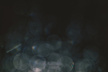 bokeh of lights made by raindrops on a windows illuminated by a torch, abstract background or texture shot © faithie