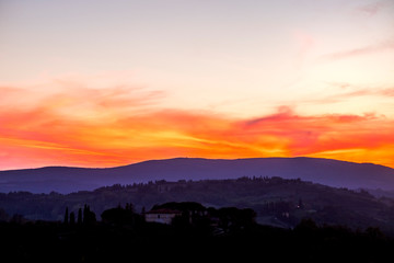 Fototapeta premium Amazing coloured sunset in Tuscany Italy with red clouds and blue ground during the blue hours. Beautiful landscape with colors and feeling