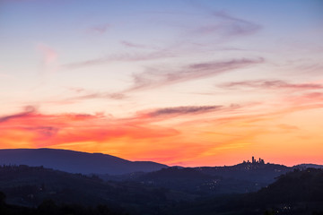 Fototapeta na wymiar San Gimignano Tuscany view after a great coloured sunset in the beautiful wine valley in Italy. Colors red and blue and ancient town tower in silhouette