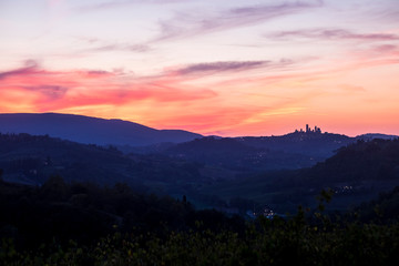 Fototapeta na wymiar Amazing coloured sunset in Tuscany Italy with red clouds and blue ground during the blue hours. Beautiful landscape with colors and feeling