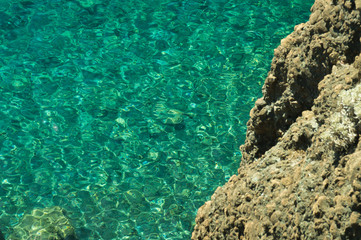 Mountain and sea. transparent water. rocky cliff