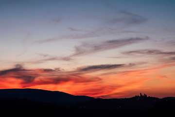 San Gimignano Tuscany view after a great coloured sunset in the beautiful wine valley in Italy. Colors red and blue and ancient town tower in silhouette