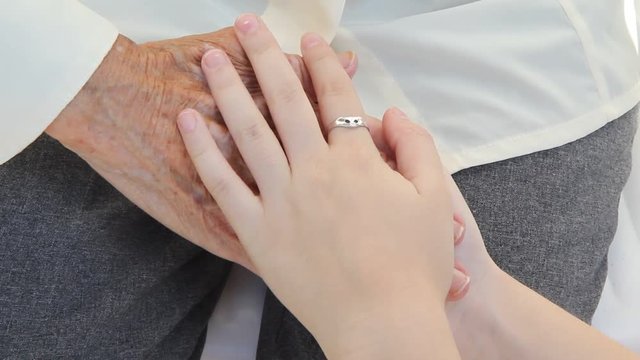 Hands of old woman and young.
