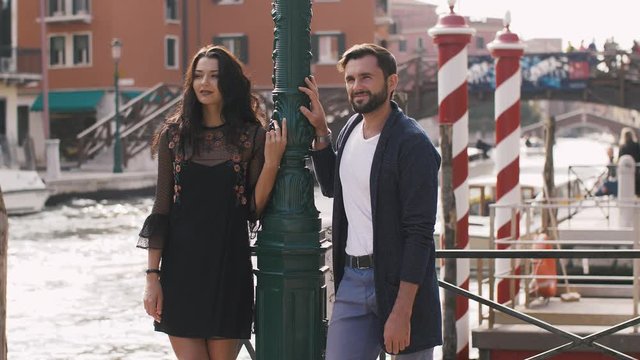 Romantic tourist couple in love in Venice, Italy on Piazza, San Marco. Happy young couple on travel vacation. Happy woman and man. Beautiful woman, handsome man in slow motion 4K UHD footage