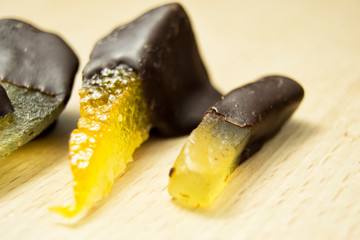 tasty dark chocolate chocolates with pear, orange and ginger on top of a wooden chopping board
